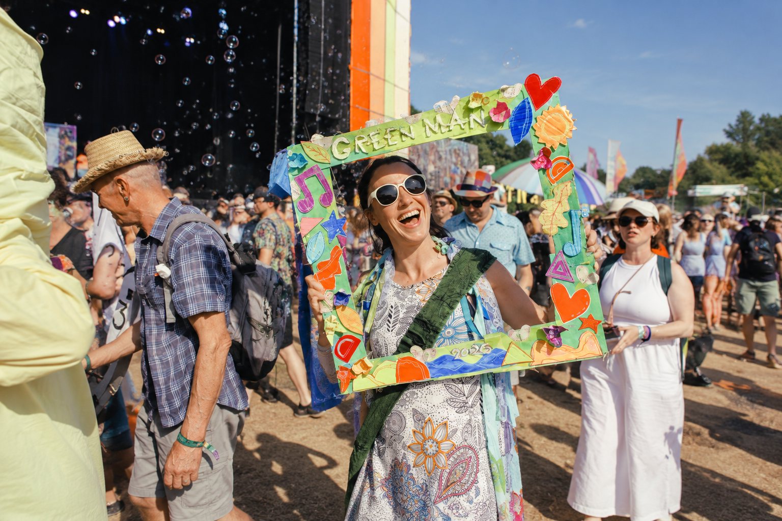 Crowd and stages at Green Man Festival with rolling hills in the background